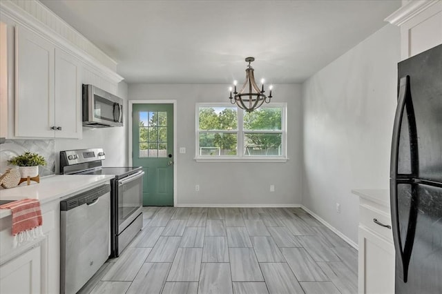 615 Ridgecrest Rd, Edmond, OK 73013 - kitchen with appliances with stainless steel finishes, a chandelier, light countertops, and white cabinetry