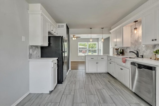 615 Ridgecrest Rd, Edmond, OK 73013 - kitchen featuring stainless steel dishwasher, a peninsula, a sink, freestanding refrigerator, and light countertops