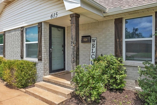615 Ridgecrest Rd, Edmond, OK 73013 - doorway to property with a shingled roof and brick siding