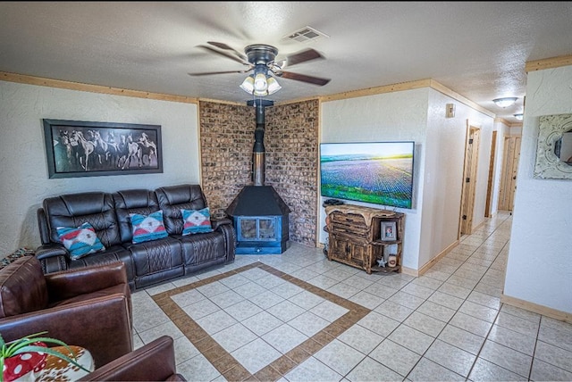 106049 N 3855-1 Rd, Weleetka, OK 74880 - living room featuring light tile patterned flooring, a wood stove, a textured wall, ceiling fan, and a textured ceiling
