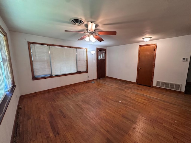 811 N Broadway St, Broken Bow, OK 74728 - unfurnished room featuring hardwood / wood-style floors, ceiling fan, baseboards, and healthy amount of natural light