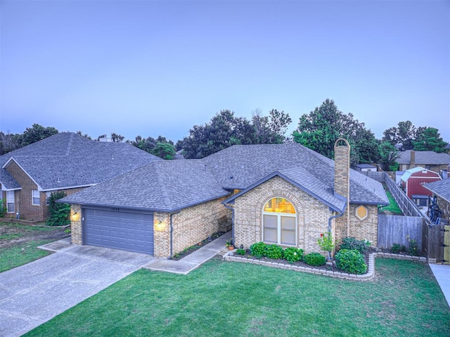 1320 Von Elm Pl, Yukon, OK 73099 - view of front facade with brick siding, an attached garage, driveway, a chimney, and a shingled roof