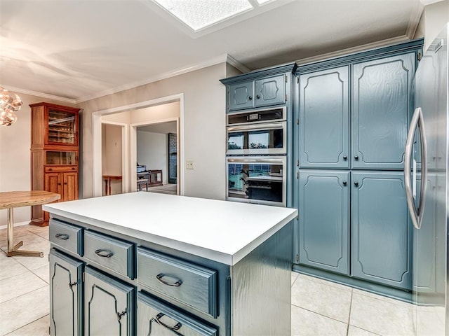 1320 Von Elm Pl, Yukon, OK 73099 - kitchen with light tile patterned flooring, appliances with stainless steel finishes, ornamental molding, blue cabinetry, and light countertops