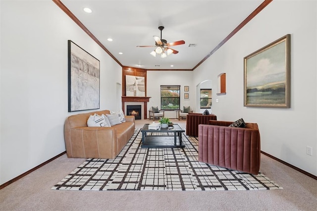 709 S Greengate Dr, Yukon, OK 73099 - living area featuring ornamental molding, a ceiling fan, carpet floors, arched walkways, and a lit fireplace