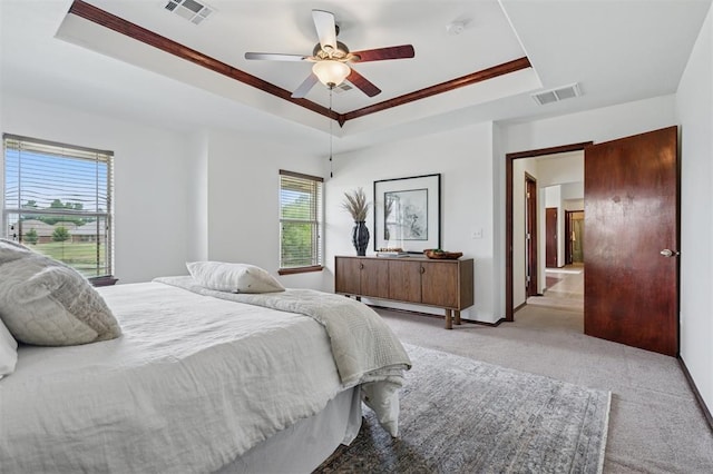 709 S Greengate Dr, Yukon, OK 73099 - bedroom featuring a tray ceiling, multiple windows, light colored carpet, and ceiling fan
