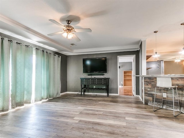 12325 Spring Meadows Rd, Yukon, OK 73099 - unfurnished living room featuring a ceiling fan, crown molding, plenty of natural light, a raised ceiling, and wood finished floors