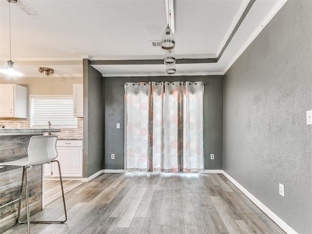 12325 Spring Meadows Rd, Yukon, OK 73099 - unfurnished dining area with crown molding, a textured wall, light wood-style floors, and baseboards