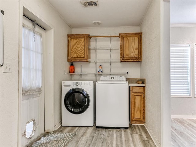 12325 Spring Meadows Rd, Yukon, OK 73099 - laundry room with light wood-type flooring, ornamental molding, washer and dryer, cabinet space, and a textured wall
