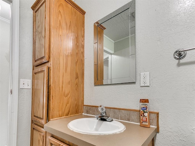 12325 Spring Meadows Rd, Yukon, OK 73099 - bathroom with a textured wall, vanity, and ornamental molding
