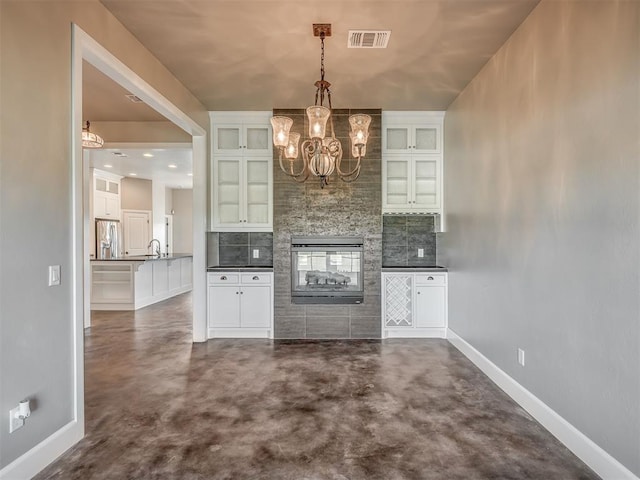 5021 SE 12th Ave, Washington, OK 73093 - bar area with stainless steel fridge, a chandelier, finished concrete flooring, and decorative backsplash