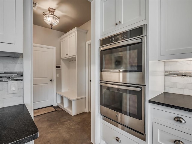 5021 SE 12th Ave, Washington, OK 73093 - kitchen featuring double oven, decorative backsplash, white cabinets, and dark countertops