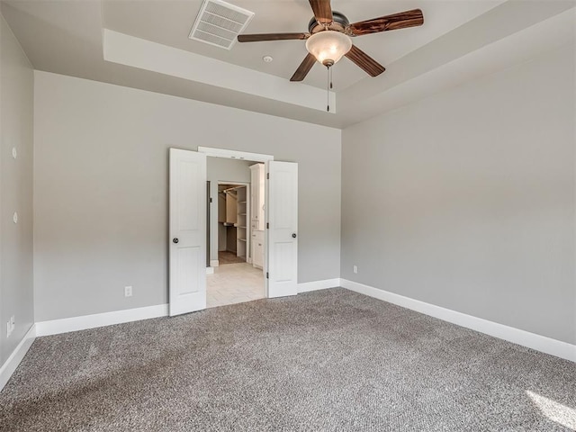 5021 SE 12th Ave, Washington, OK 73093 - unfurnished bedroom with a raised ceiling, carpet flooring, and a walk in closet