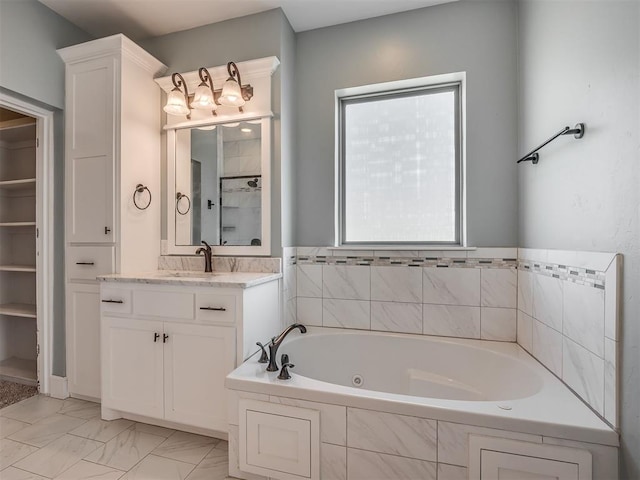 5021 SE 12th Ave, Washington, OK 73093 - bathroom featuring a jetted tub, vanity, and marble look tile flooring