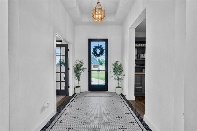 1049 Dorsi Way, Newcastle, OK 73065 - entrance foyer with baseboards, a chandelier, a tray ceiling, and wood finished floors