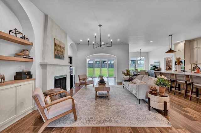 1049 Dorsi Way, Newcastle, OK 73065 - living room featuring a chandelier, wood finished floors, a fireplace, recessed lighting, and arched walkways