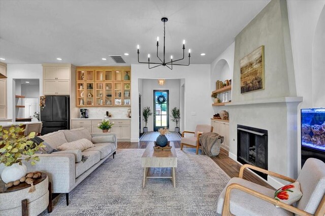 1049 Dorsi Way, Newcastle, OK 73065 - living room featuring recessed lighting, wood finished floors, a chandelier, and a fireplace