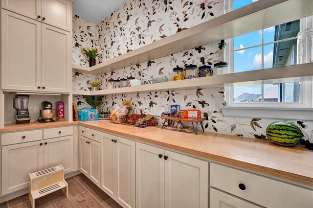 1049 Dorsi Way, Newcastle, OK 73065 - kitchen with open shelves, light countertops, wallpapered walls, and white cabinets