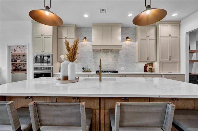 1049 Dorsi Way, Newcastle, OK 73065 - kitchen with custom exhaust hood, appliances with stainless steel finishes, a large island with sink, light stone countertops, and a kitchen bar