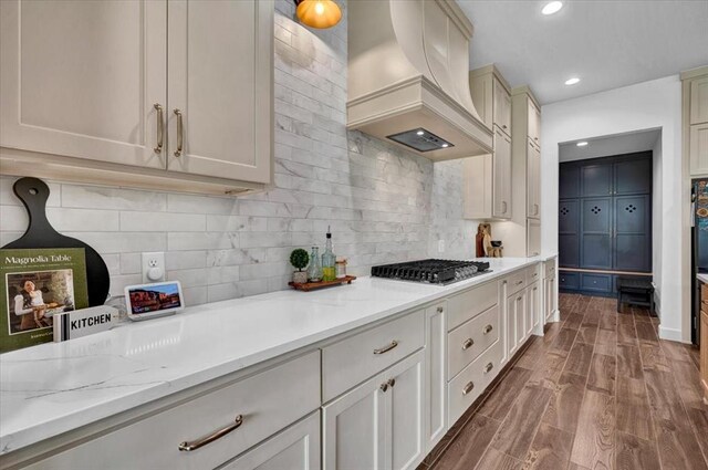 1049 Dorsi Way, Newcastle, OK 73065 - kitchen featuring custom range hood, stainless steel gas cooktop, wood finished floors, recessed lighting, and tasteful backsplash