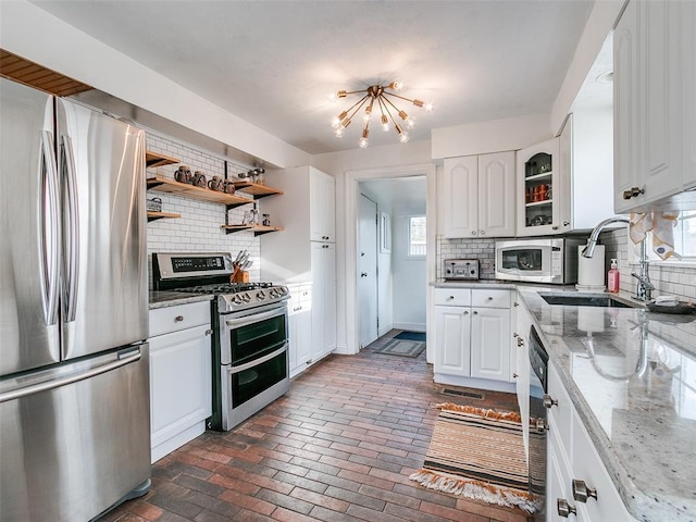 2647 NW 24th St, Oklahoma City, OK 73107 - kitchen featuring stainless steel appliances, a sink, a chandelier, and decorative backsplash