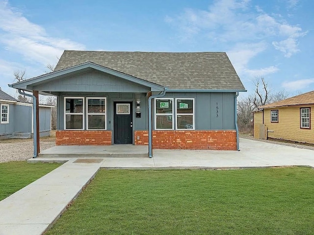 1533 NE 26th St, Oklahoma City, OK 73111 - view of front facade featuring a front lawn, brick siding, and a shingled roof