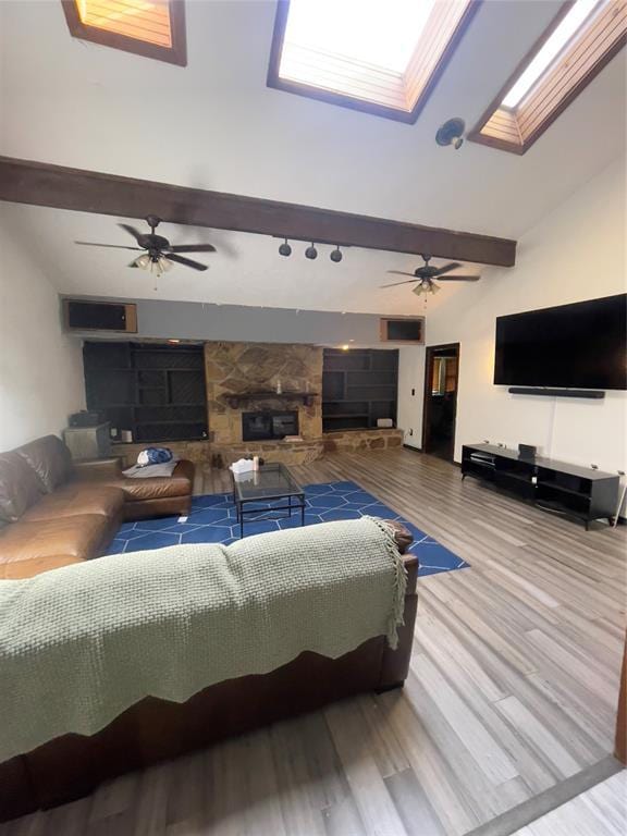 8228 NW 90th Ter, Oklahoma City, OK 73132 - living area with wood finished floors, a fireplace, a skylight, a ceiling fan, and beamed ceiling