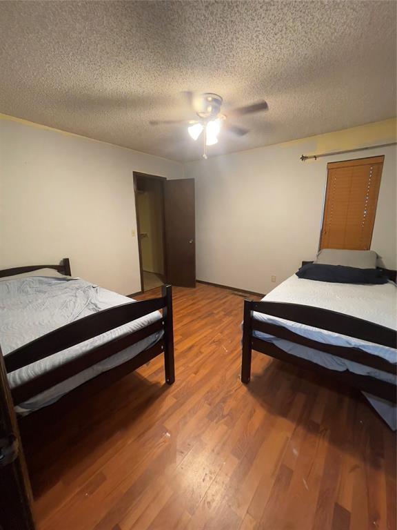 8228 NW 90th Ter, Oklahoma City, OK 73132 - bedroom with light wood-style flooring, a textured ceiling, and a ceiling fan