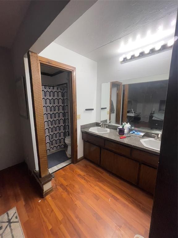 8228 NW 90th Ter, Oklahoma City, OK 73132 - bathroom with wood finished floors, double vanity, and a shower with curtain