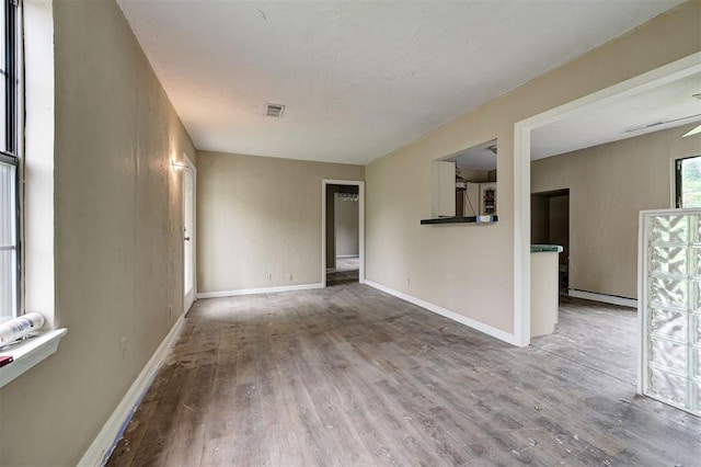 4110 SE 11th St, Oklahoma City, OK 73115 - unfurnished living room with wood finished floors and a baseboard heating unit