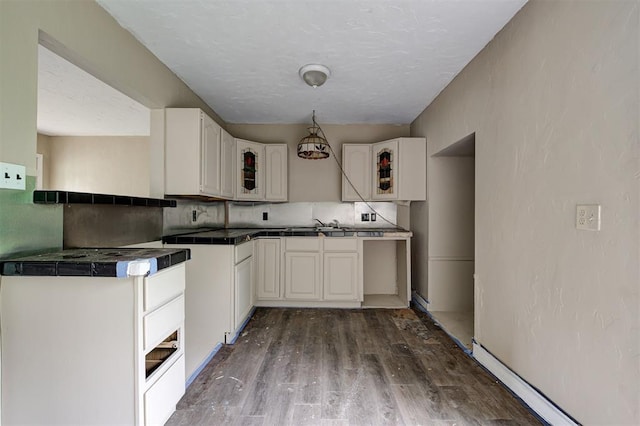 4110 SE 11th St, Oklahoma City, OK 73115 - kitchen with glass insert cabinets, dark wood finished floors, tile countertops, decorative backsplash, and white cabinets