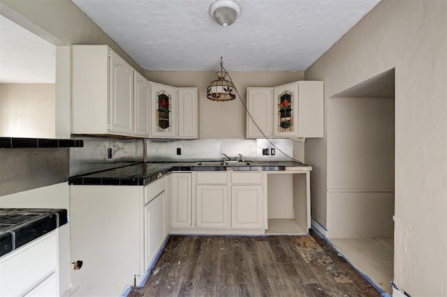 4110 SE 11th St, Oklahoma City, OK 73115 - kitchen with dark wood-style flooring, glass insert cabinets, white cabinets, decorative backsplash, and a textured ceiling