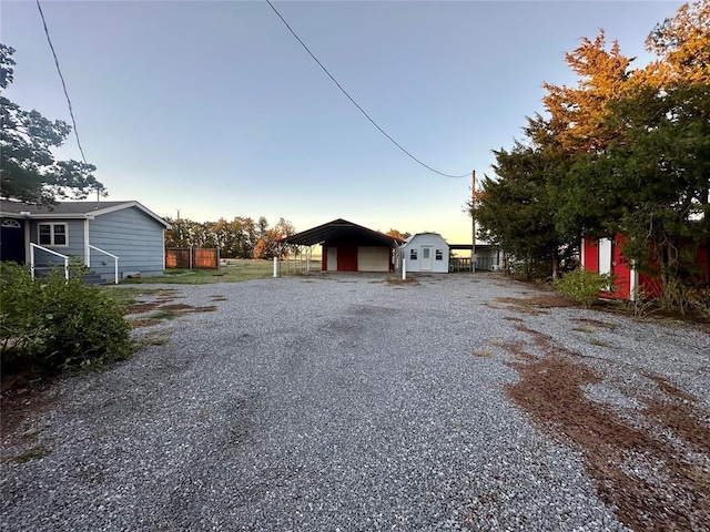 20973 US Highway 62, Altus, OK 73521 - view of side of home featuring gravel driveway, a detached garage, and a detached carport