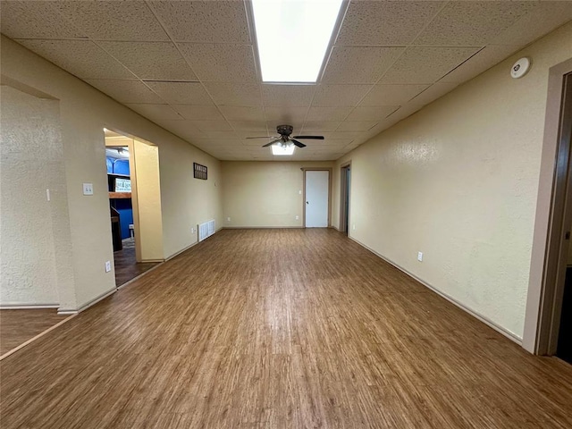 20973 US Highway 62, Altus, OK 73521 - empty room with wood finished floors, a paneled ceiling, ceiling fan, baseboards, and a smoke detector