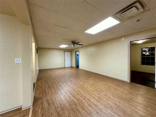 20973 US Highway 62, Altus, OK 73521 - empty room with a paneled ceiling, wood finished floors, a textured wall, a ceiling fan, and baseboards