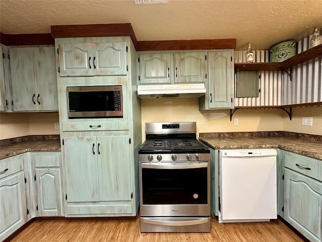20973 US Highway 62, Altus, OK 73521 - kitchen with stainless steel appliances, under cabinet range hood, open shelves, dark countertops, and a textured ceiling