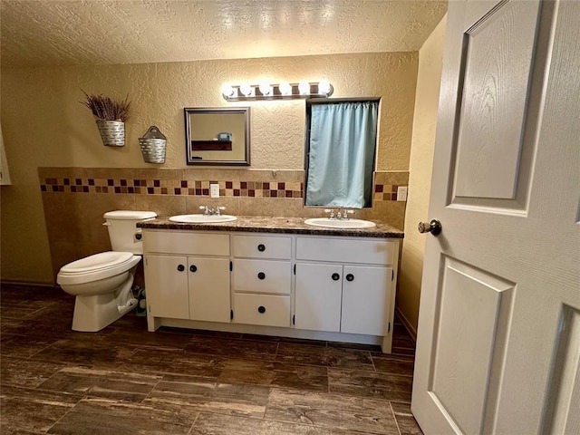 20973 US Highway 62, Altus, OK 73521 - bathroom featuring a textured wall, double vanity, a textured ceiling, and toilet
