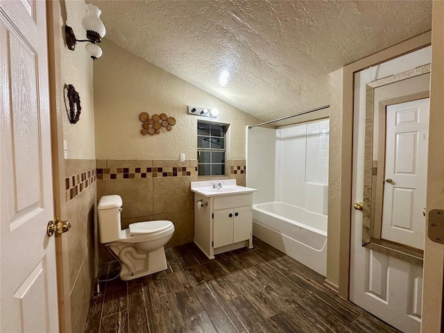 20973 US Highway 62, Altus, OK 73521 - full bathroom featuring a textured ceiling, tile walls, vanity, a textured wall, and toilet