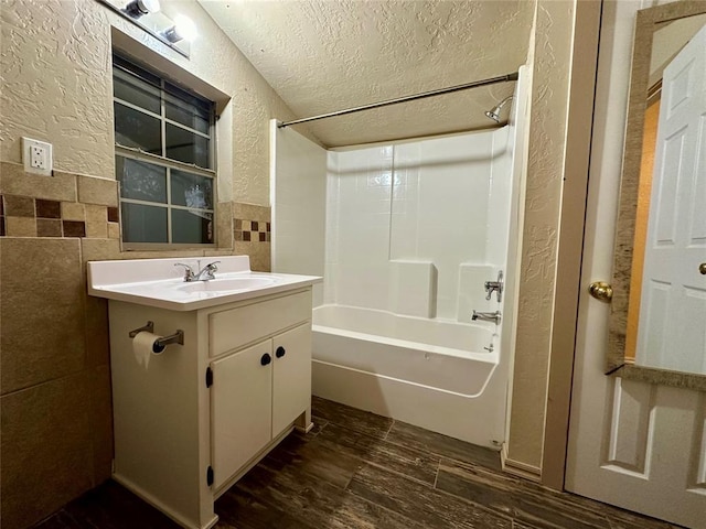 20973 US Highway 62, Altus, OK 73521 - full bathroom featuring a textured wall, tile walls, tub / shower combination, a textured ceiling, and vanity