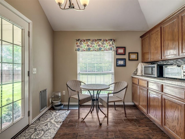 1816 Concord Pl, Norman, OK 73071 - dining space featuring vaulted ceiling, a chandelier, dark wood-style flooring, and baseboards