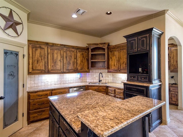 866 County St Unit 2922, Tuttle, OK 73089 - kitchen featuring a sink, open shelves, arched walkways, tasteful backsplash, and a kitchen island