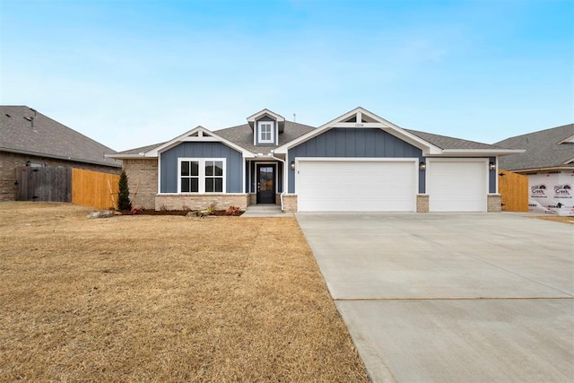 1208 Ariana St, Shawnee, OK 74804 - view of front of house with board and batten siding, an attached garage, driveway, and brick siding