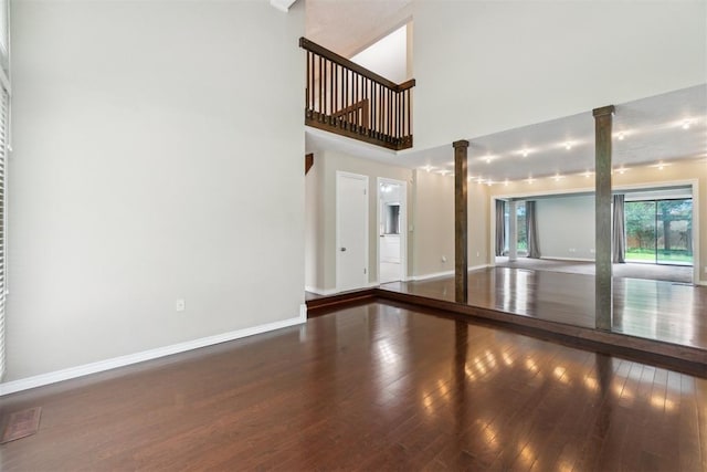 4208 Briarcrest St, Norman, OK 73072 - unfurnished living room with ornate columns, hardwood / wood-style floors, and a high ceiling
