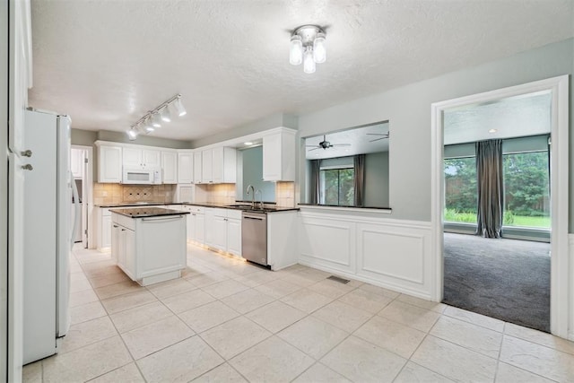 4208 Briarcrest St, Norman, OK 73072 - kitchen featuring white appliances, dark countertops, light tile patterned floors, a ceiling fan, and rail lighting