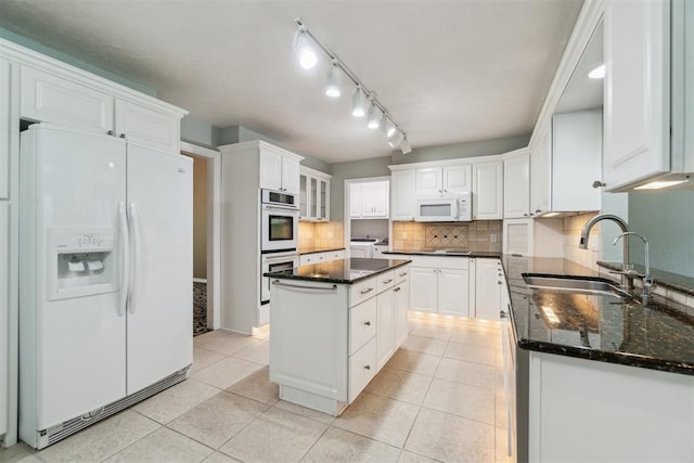 4208 Briarcrest St, Norman, OK 73072 - kitchen featuring white appliances, white cabinets, decorative backsplash, light tile patterned floors, and dark stone countertops