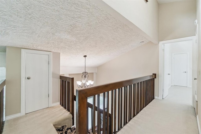 4208 Briarcrest St, Norman, OK 73072 - hall featuring carpet, a chandelier, an upstairs landing, and a textured ceiling