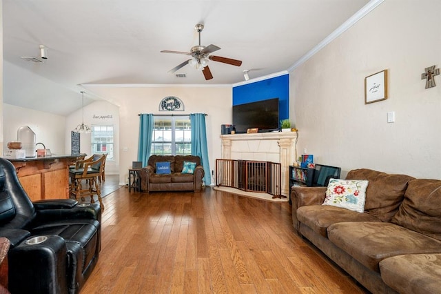 2365 Turtlewood River Rd, Midwest City, OK 73130 - living room with a ceiling fan, hardwood / wood-style flooring, ornamental molding, and a fireplace with raised hearth