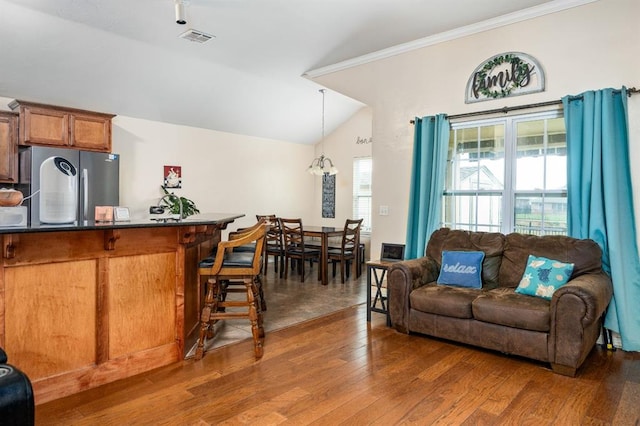 2365 Turtlewood River Rd, Midwest City, OK 73130 - living area featuring vaulted ceiling, wood finished floors, and crown molding