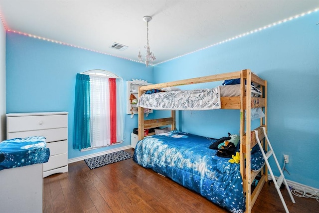 2365 Turtlewood River Rd, Midwest City, OK 73130 - bedroom with wood finished floors, baseboards, and a chandelier