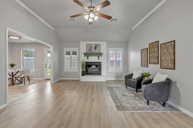 2309 NW 157th Ter, Edmond, OK 73013 - sitting room with vaulted ceiling, light wood-type flooring, ceiling fan, baseboards, and a brick fireplace