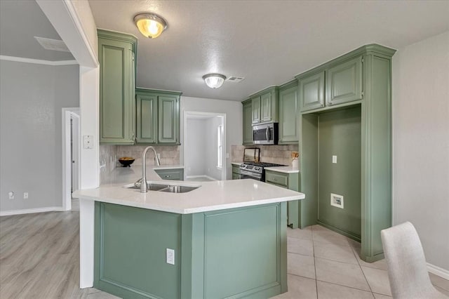 2309 NW 157th Ter, Edmond, OK 73013 - kitchen featuring green cabinetry, a sink, appliances with stainless steel finishes, and a peninsula